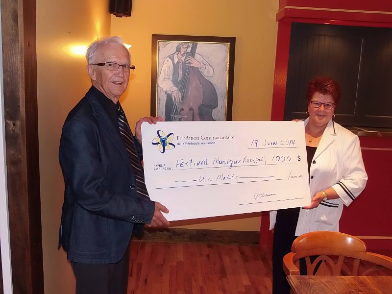 Le président de la Fondation communautaire, Germain Blanchard, remet un don de 1 000 $ au Festival International de Musique Baroque de Lamèque.